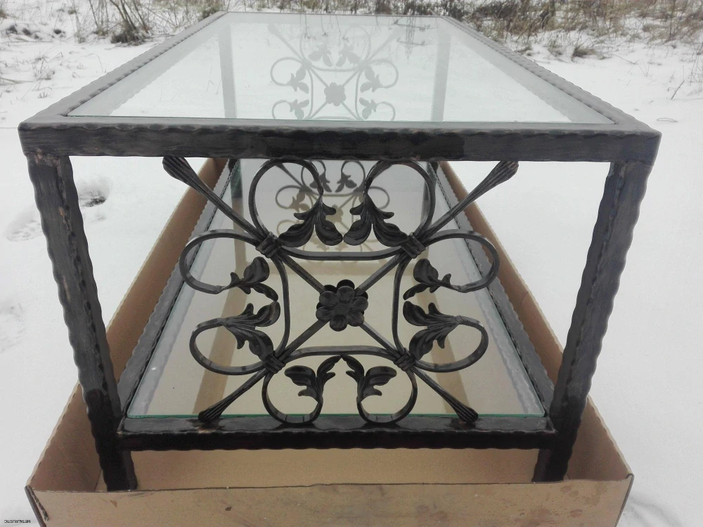 Kovaný konferenčný stolík s čírym sklom a ornamentom so závitnicami na boku
