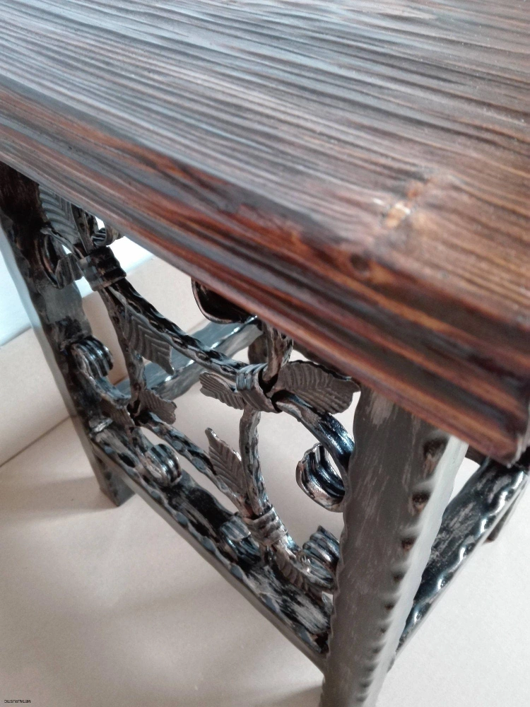 Detail hrany sedáka z masívneho smreku hrubého 4 cm nad kovanými ornamentmi