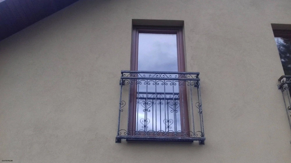Zábradlie na francúzske okno na úzkom vysokom okne, čierny kovaný francúzsky balkón